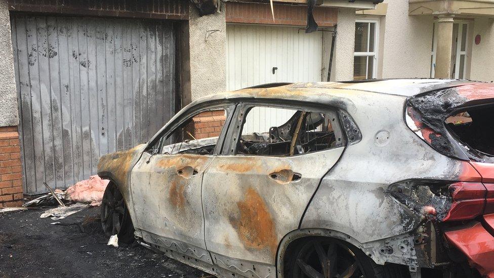 Fire damaged car and house