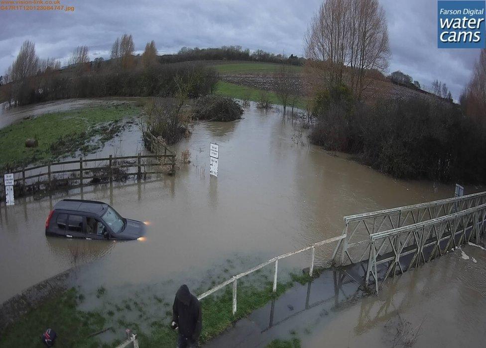 A car stranded in brown floodwater