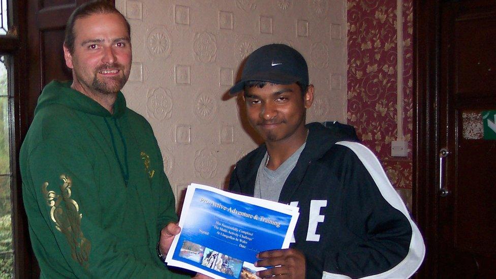 Clive Richley presenting a certificate to a young visitor before the pandemic