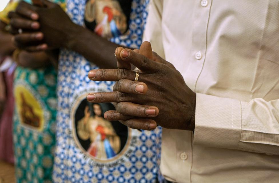 Man's hands clasped in prayer