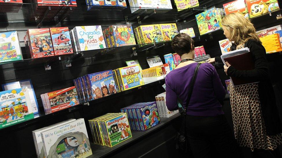 Two women looking at games on a shelf