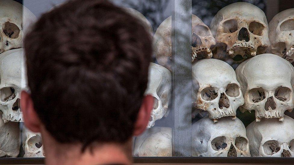 A visitor looks at the main stupa in Choeung Ek Killing Fields, which is filled with thousands of skulls of those killed during the Pol Pot regime on August 6, 2014 in Phnom Penh, Cambodia.