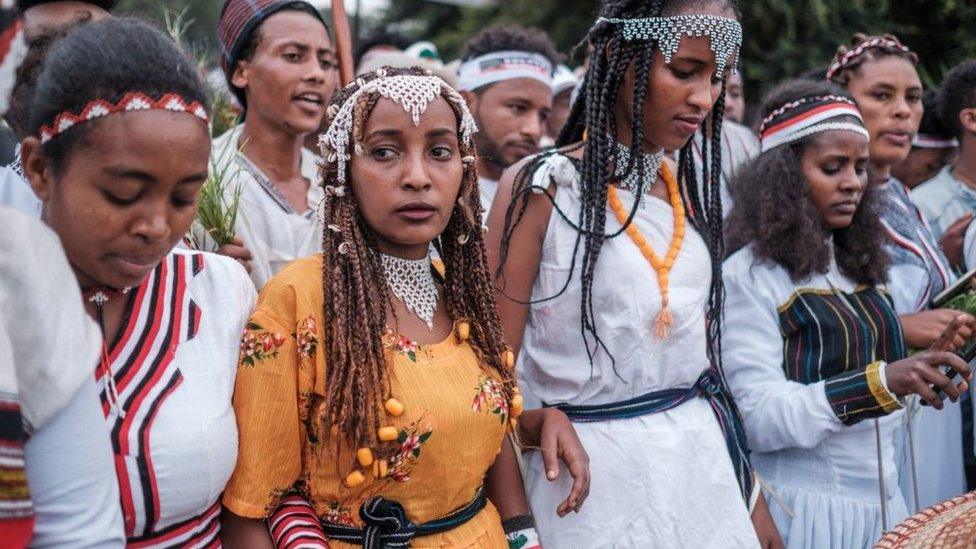 Women in traditional clothing march during the celebration of Irreechaa, the Oromo people thanksgiving holiday, on the shore of a lake near the city of Bishoftu, Ethiopia - October 2021