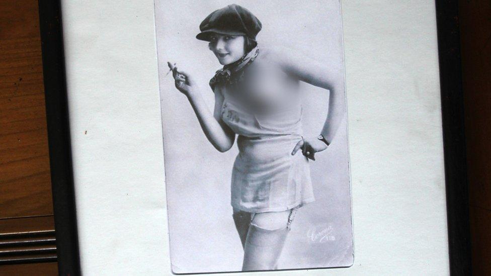 Another picture, a woman wearing a cap pulls down her dress to expose her breast