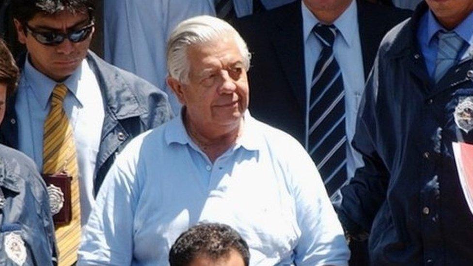 In this Jan. 28, 2005 file photo, retired Gen. Manuel Contreras, center, who headed the security service under former dictator Gen. Augusto Pinochet, leaves police headquarters in Santiago, Chile.