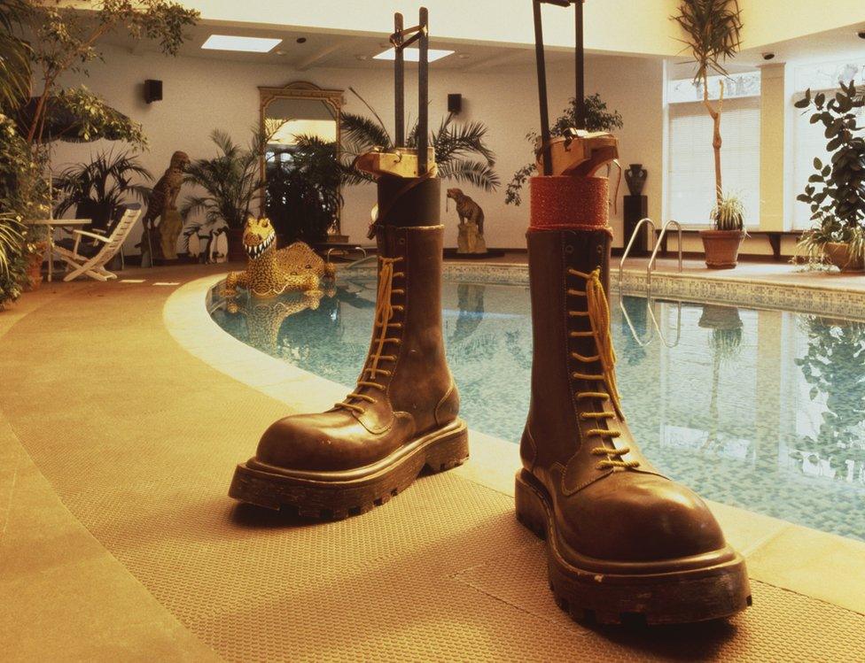 A pair of outsize Dr Martens boots by the pool at Elton John's home in Berkshire, circa 1988. The boots were worn by John in his role as The Pinball Champ in the 1975 rock opera 'Tommy', directed by Ken Russell