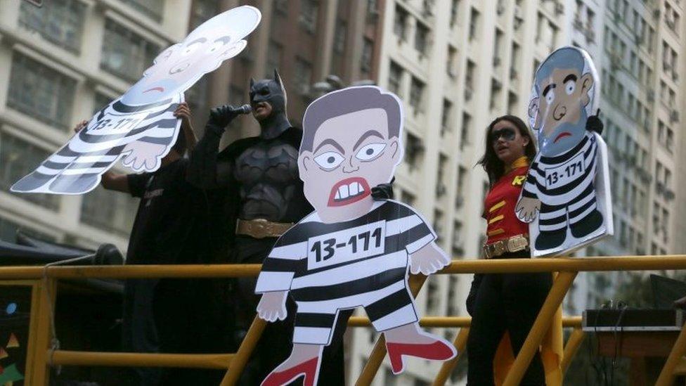 A demonstrator dressed as Batman speaks next to cardboard cut-outs depicting Dilma Rousseff and former President Luiz Inacio Lula da Silva during a protest in Rio de Janeiro on 3 September, 2015