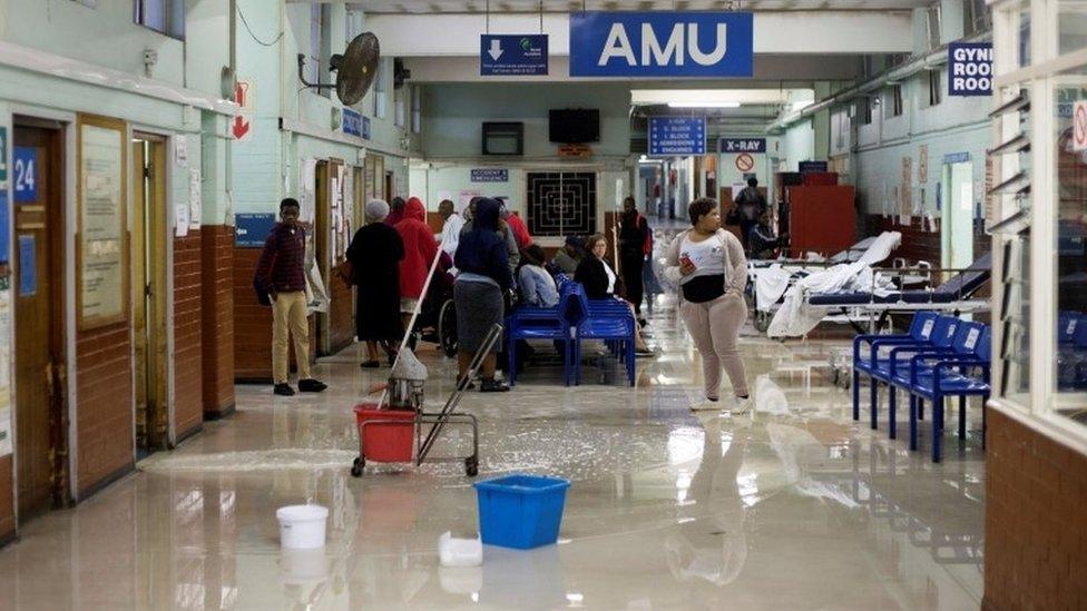 Cleaners mop up water at King Edward VIII Hospital during a storm in Durban, South Africa, 10 October 2017