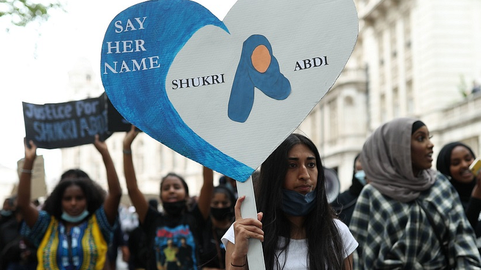 demonstrators hold placards