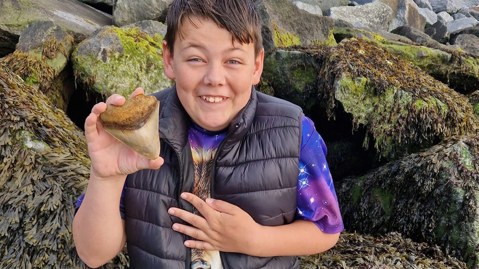 Ben with the 10cm-long tooth he found at Walton-on-the-Naze in Essex