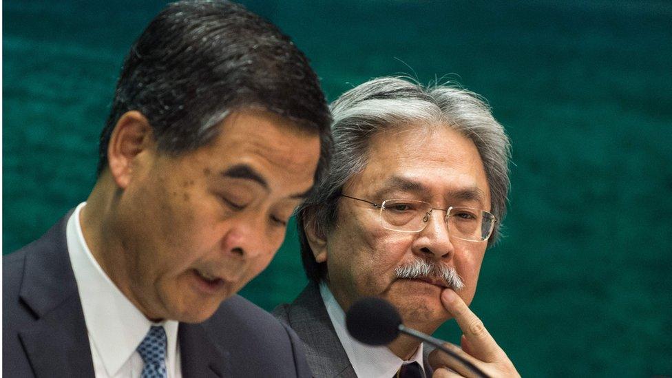 This file photo taken on September 21, 2016 shows Hong Kong's Financial Secretary John Tsang Chun-wah (R) gesturing as Hong Kong"s Chief Executive Leung Chun-ying writes notes during a press conference in the Central Government office in Hong Kong.