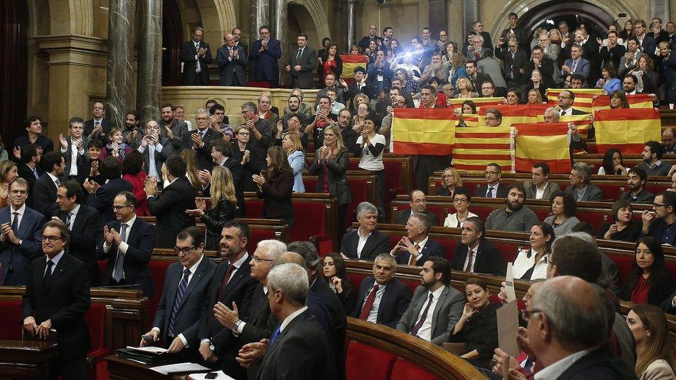 Popular Party of Catalonia members, right, show Spanish flags and Catalonia flags at the end of a parliamentary session at the parliament in Barcelona