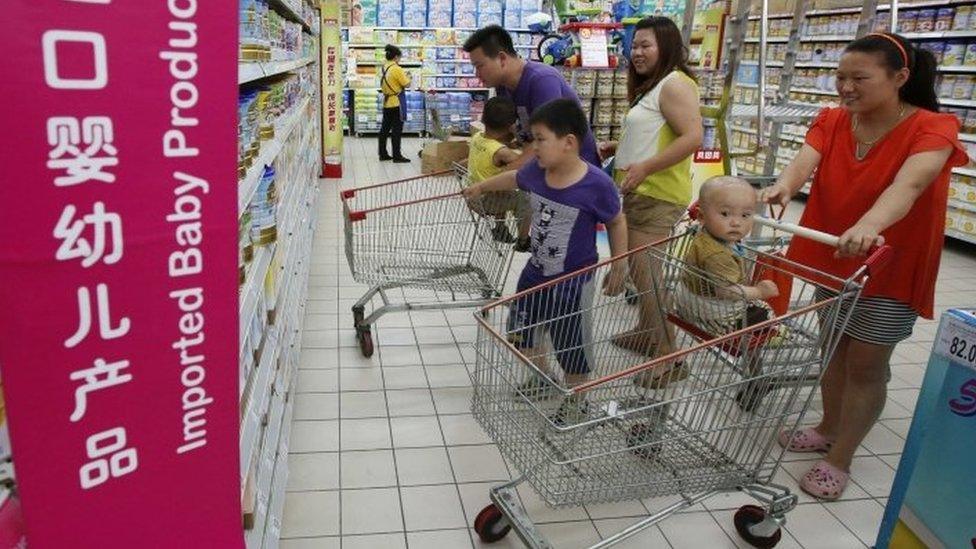 A family looks at imported milk powder products at a supermarket in Beijing in this July 3, 2013 file photo.