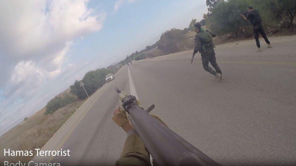 Still from video showing Hamas militants point gun at car on road