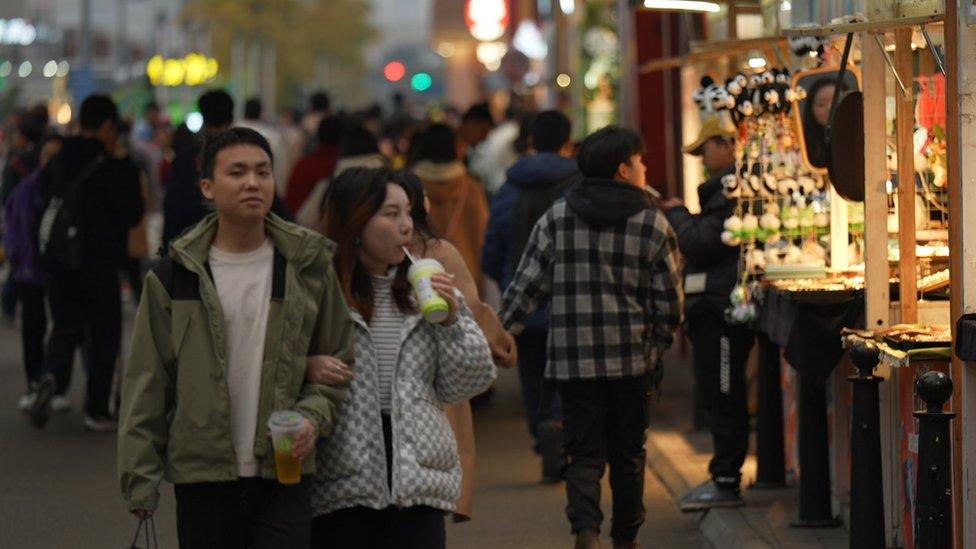 A couple walking down a street in Chengdu