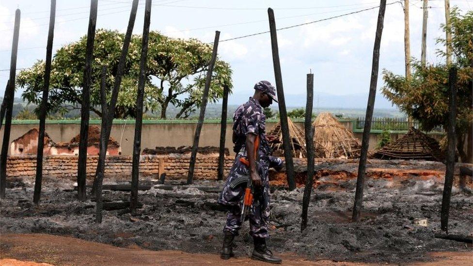 A Ugandan soldier carries his weapon as he guards the burnt down royal palace of Charles Wesley Mumbere, king of the Rwenzururu
