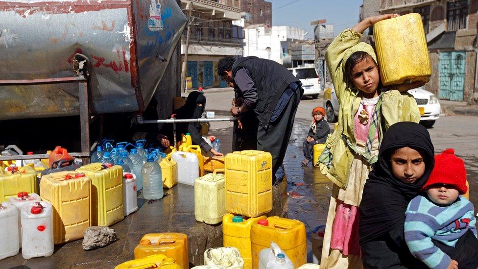 A girl carries a jerry-can filled with potable water from a charity tank in Sanaa, Yemen (19 November 2016)