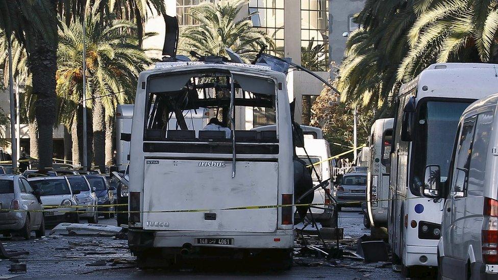 A damaged bus is seen at the scene of a bomb attack in Tunis