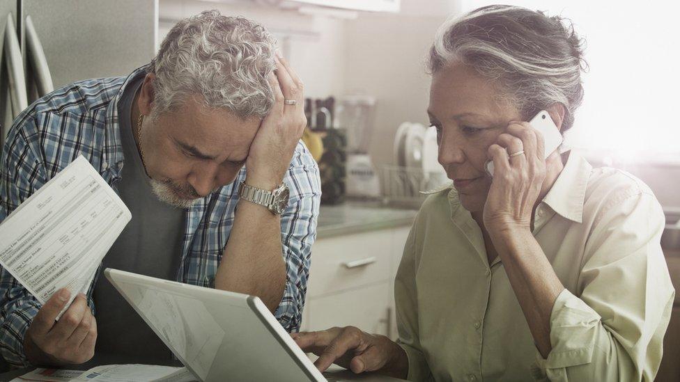 Woman and man sat at a table looking over a bill