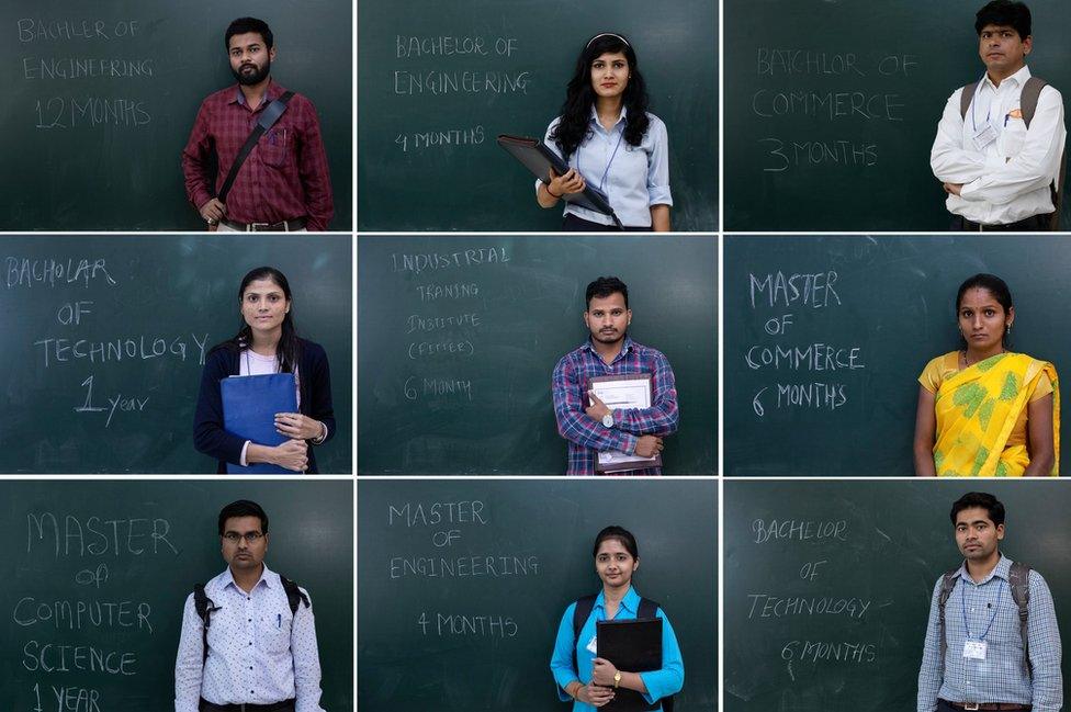 Unemployed Indians pose in front of a blackboard with their qualifications