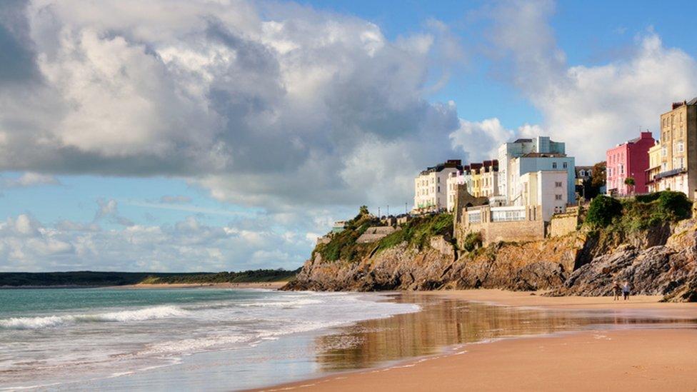 Pastel painted houses on the rocky coastline at Tenby, raised above Castle Beach.