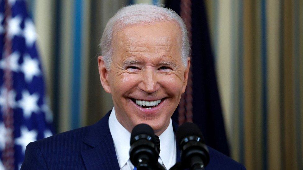 Joe Biden smiles during a press conference