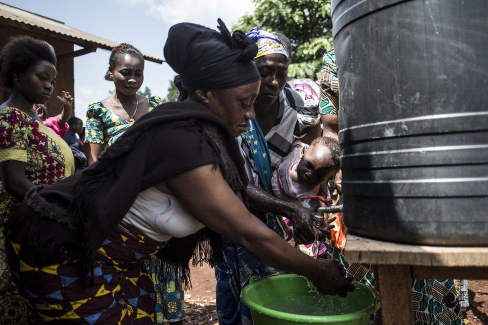 Congolese women are seen washing their hands at a chlorinated hand washing point in Mangina