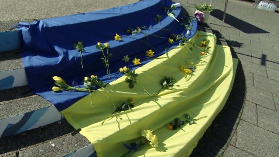 Flowers laid on a Ukrainian flag