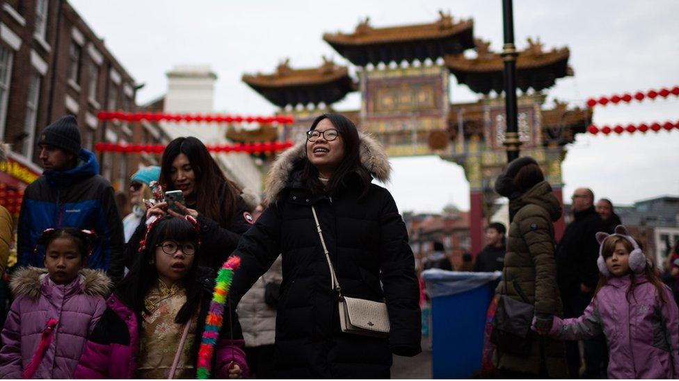 people walk in front of Liverpool Chinatown