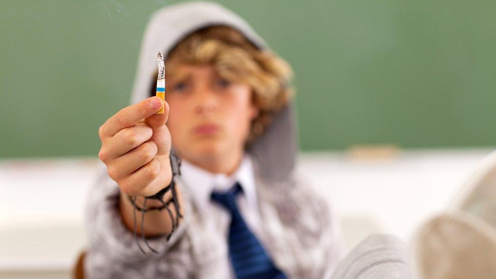 Pupil brandishes cigarette