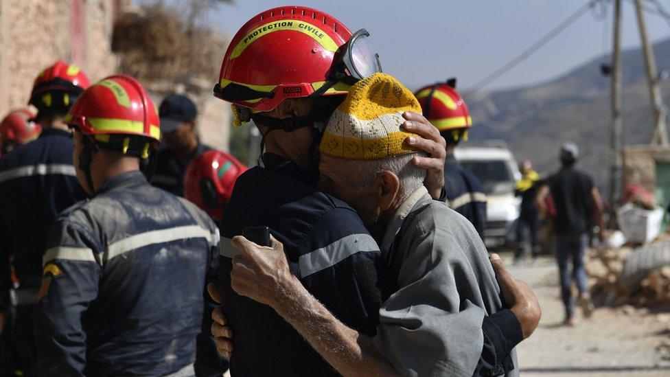 A rescuer comforts an earthquake survivor in the Moroccan town of Amizmiz