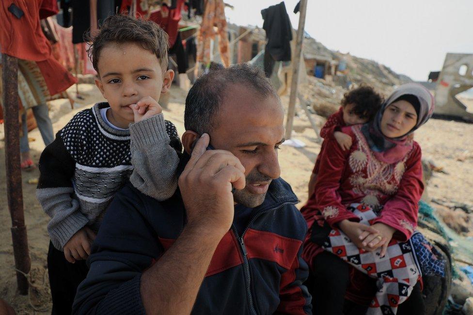 Mahmoud al-Motawag and his family, waiting for their clothes to dry on the beach in Deir al-Balah.