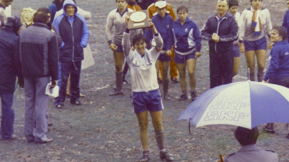 Carol Thomas lifting a trophy