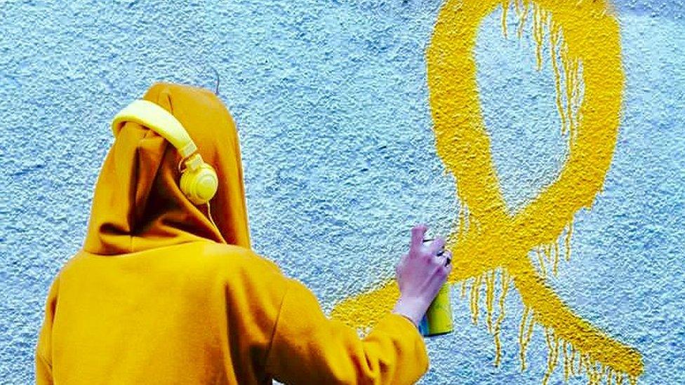 Jaimee painting the Endometriosis wall of her home