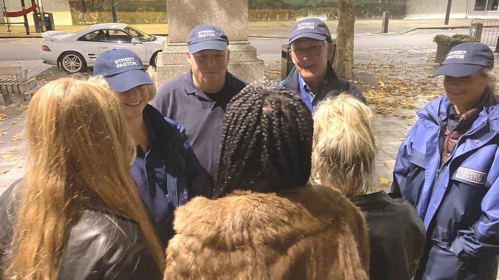 Street Pastors talking to three young women at Market Square, Salisbury