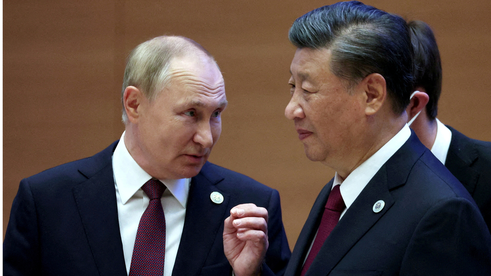 Russian President Vladimir Putin speaks with Chinese President Xi Jinping before an extended-format meeting of heads of the Shanghai Cooperation Organization summit