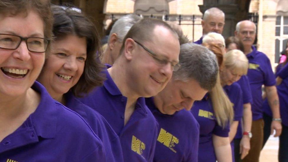 People wearing a purple uniform t-shire standing in a line