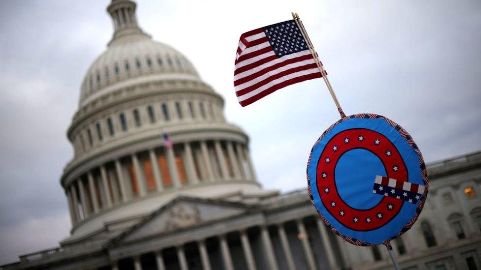 Supporters of U.S. President Donald Trump fly a U.S. flag with a symbol from the group QAnon as they gather outside the U.S. Capitol January 06, 2021 in Washington, DC