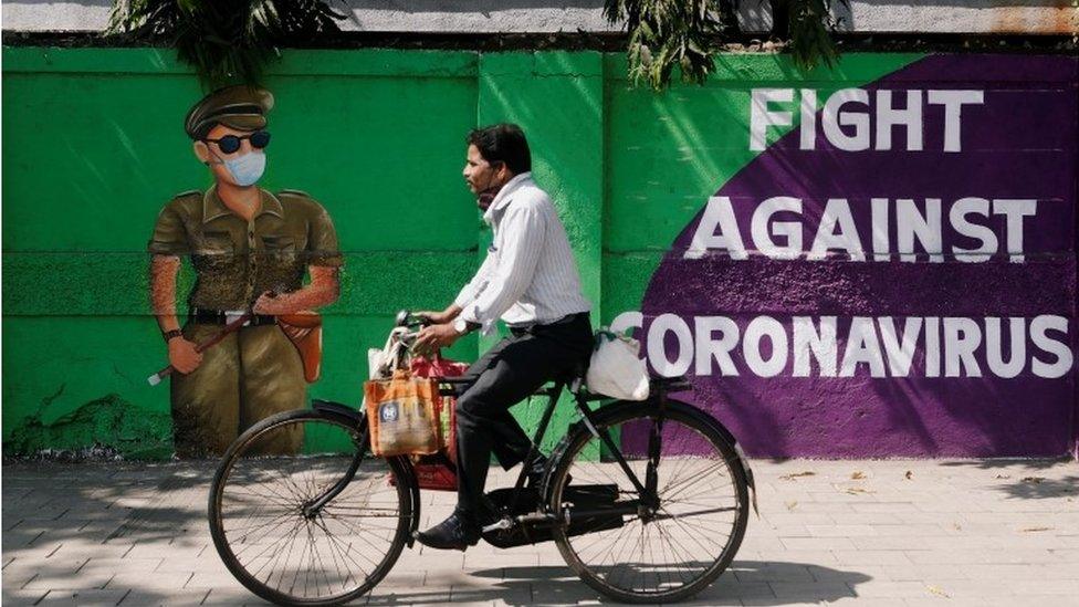 A man cycles past a graffiti covered wall amidst the spread of the coronavirus disease (COVID-19) on a street in Navi Mumbai, India January 21, 2021.