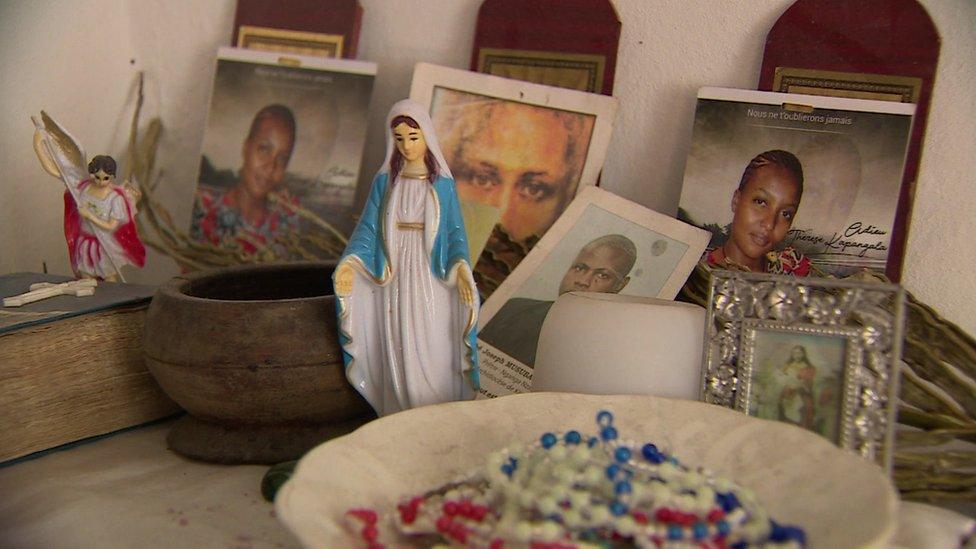 Photographs, a model of the Virgin Mary and Rosary beads are part of a shrine to Thérèse Kapangala at her family's home