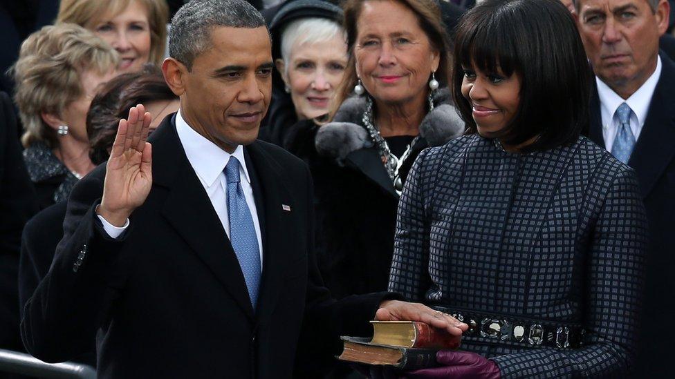 US President Barack Obama is sworn in during the public ceremony as First lady Michelle Obama looks on during the presidential inauguration