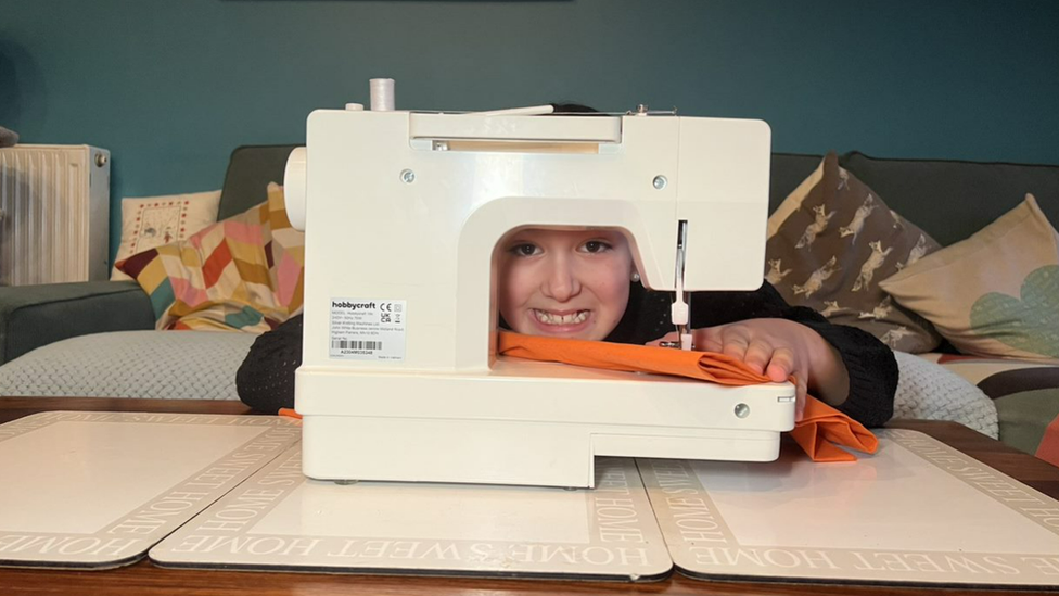 Andre posing for his sewing machine