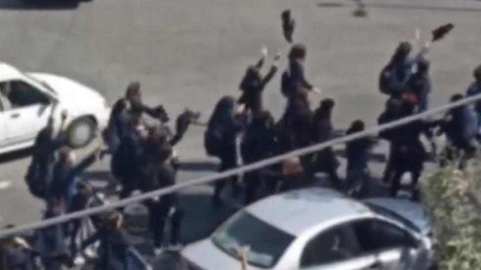 Protesting schoolgirls walk along a main road in Karaj, a city just to the west of Tehran (4 October 2022)