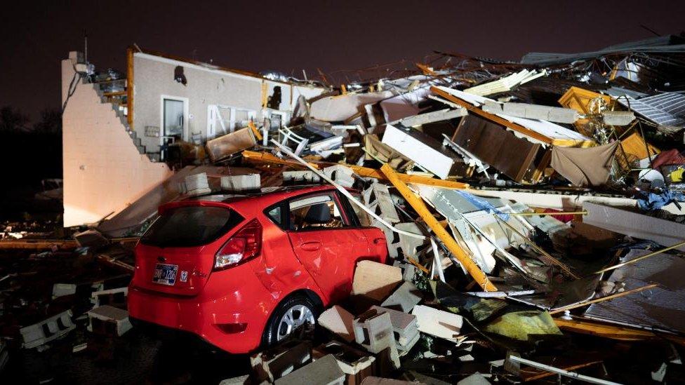 A car and a damaged building