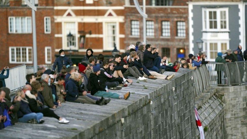 Crowds wait to watch HMS Queen Elizabeth depart HM Naval Base