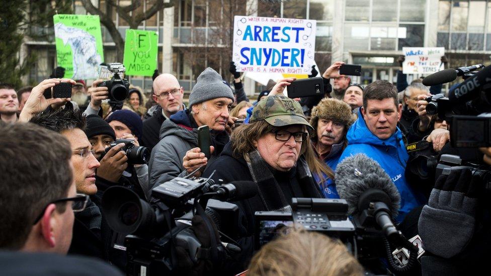 Flint, Michigan, native and filmmaker Michael Moore attends a rally outside city hall in Flint on 16 January 2016