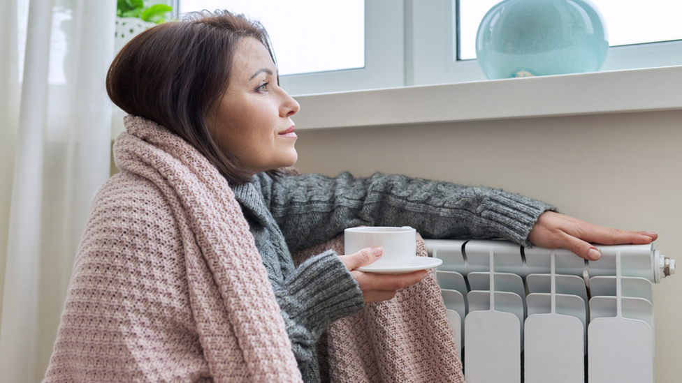 Women warms herself at a radiator