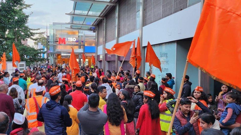 Orange flags being waved at the celebration by a group of people