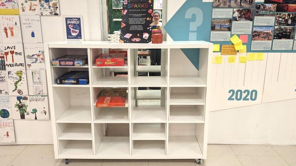 a board game swap station, shelves with board games on