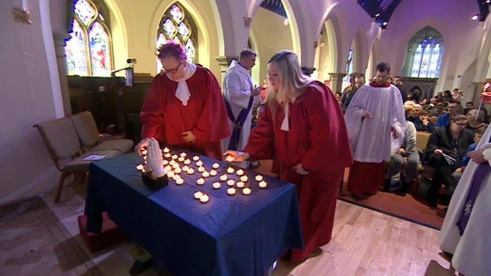 People lighting candles during the service